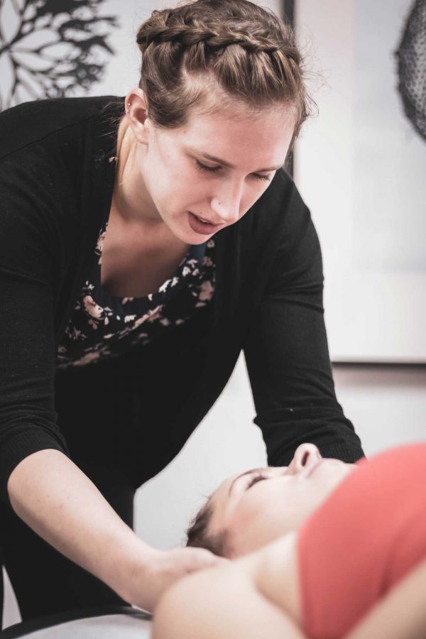 Image of woman performing a chiropractic adjustment on another woman.