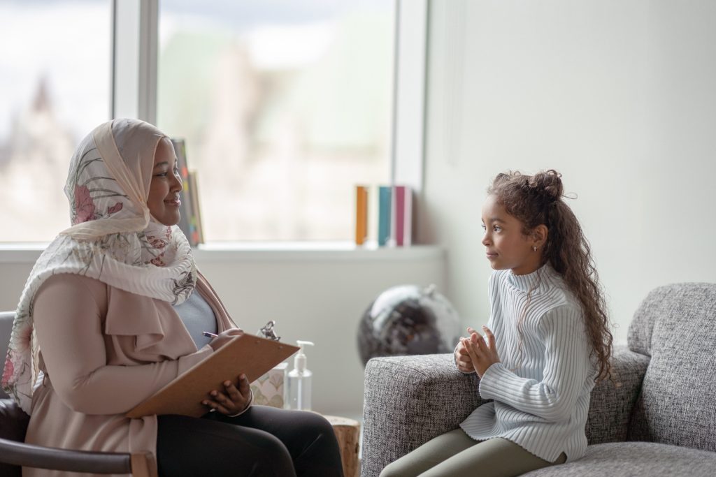 Female Psychologist working with young girl.