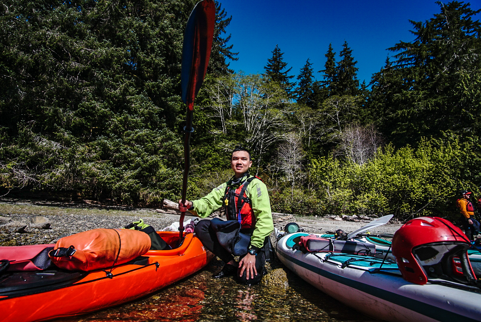ATBO student crouching near kayaks.