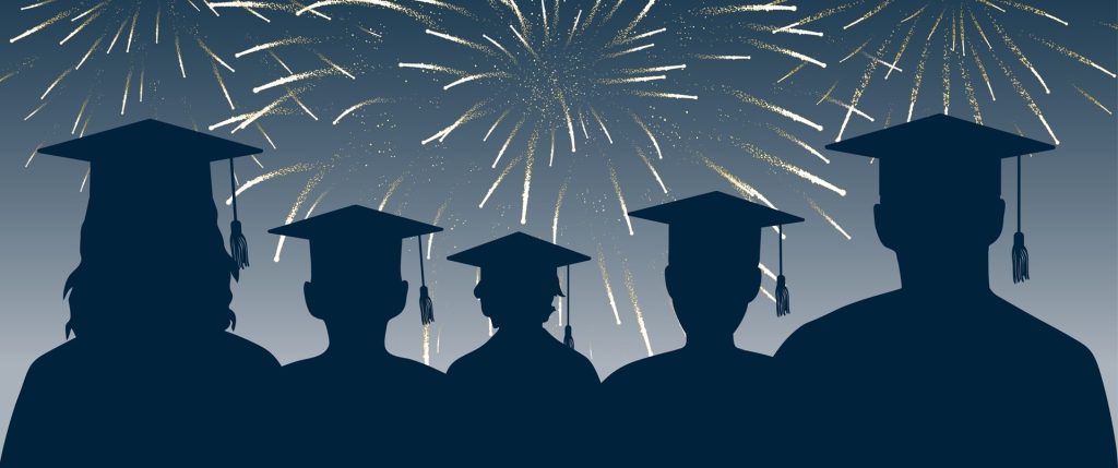 Graduates looking at fireworks, silhouette.