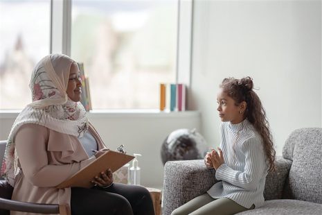 Image shows woman and child having a conversation in an office.