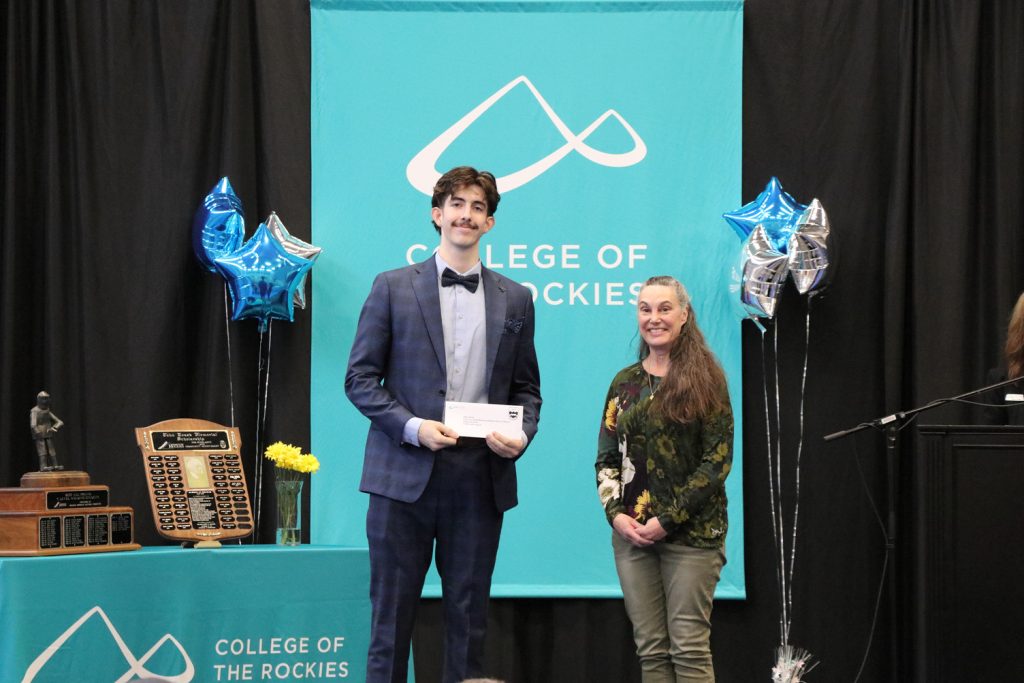 Donor posing with award recipient at ceremony.