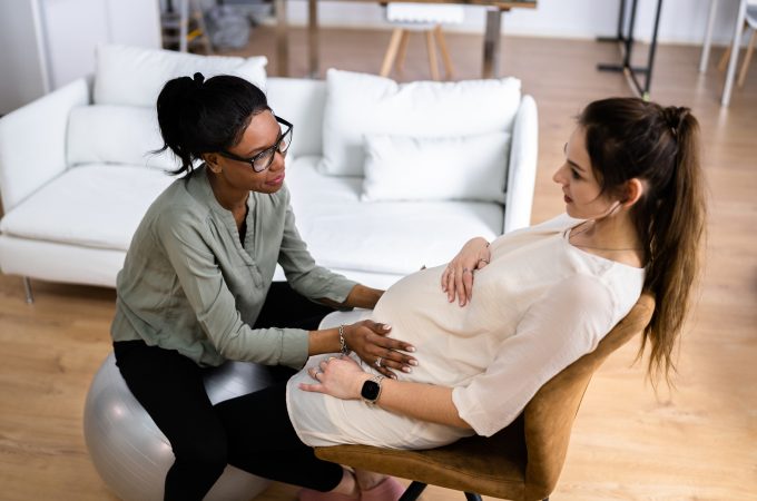 Birth Doula giving pregnant woman a checkup.