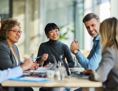 Group of happy multiracial entrepreneurs communicating during a meeting in the office.