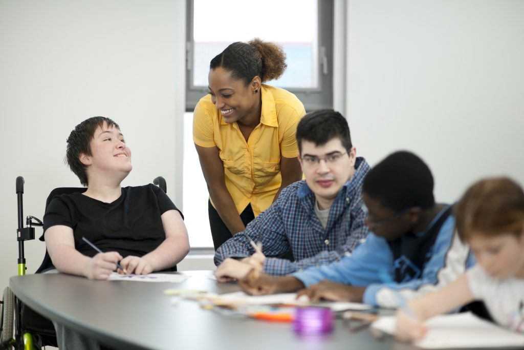 Diverse group of students with disabilities doing arts and crafts.