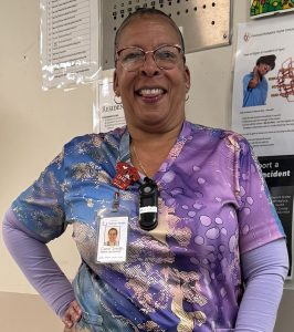 Image show woman in scrubs and badge smiling at the camera