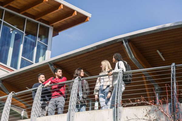 Image shows five students casually hanging out in front of College of the Rockies front entrance.