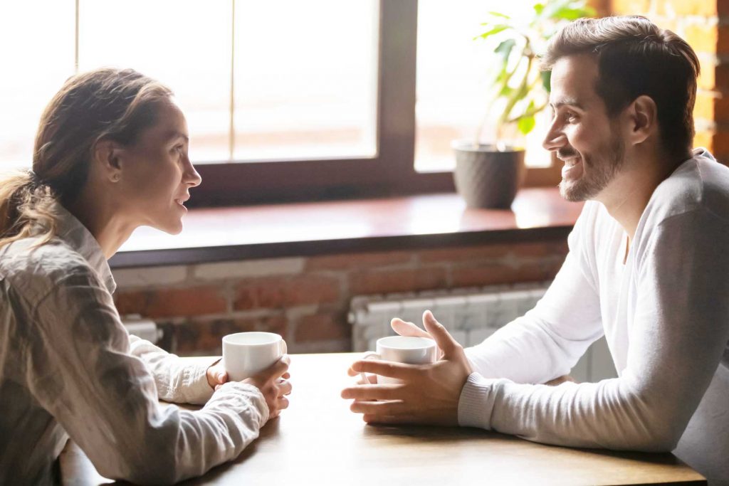 An image of a male and female chatting and having coffee.
