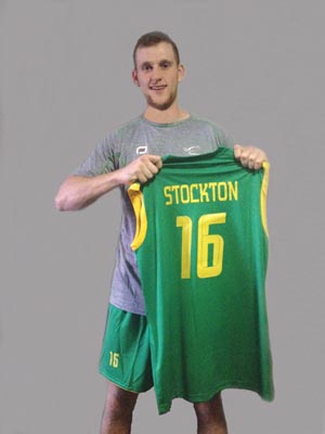 Image of College alum Curtis Stockton holding his national team jersey.