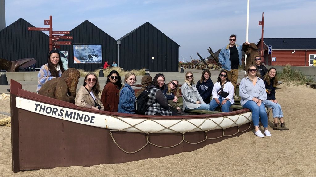 Several college students in a boat sitting on dry land in Denmark