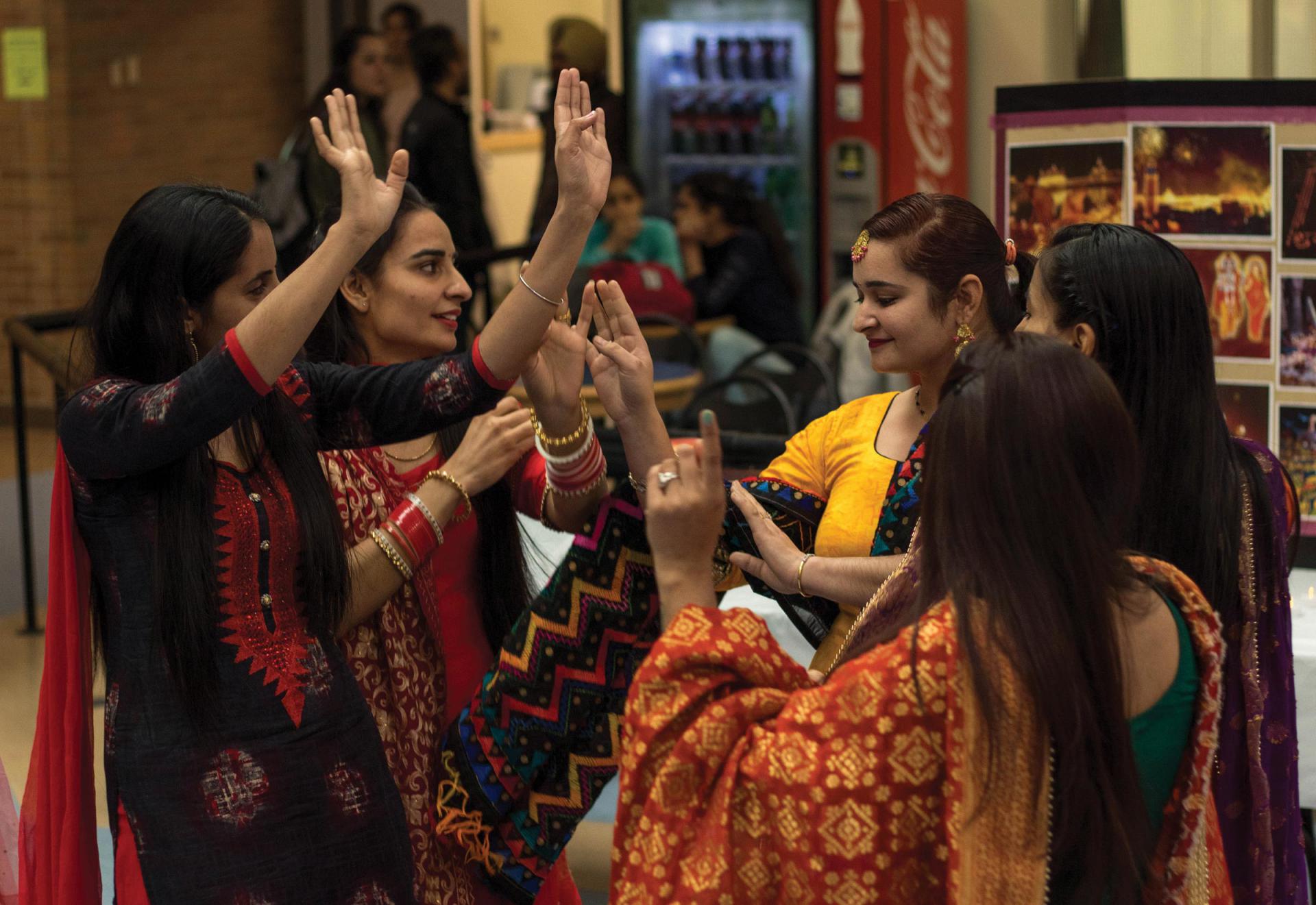 Image of women in colourful dress dancing.