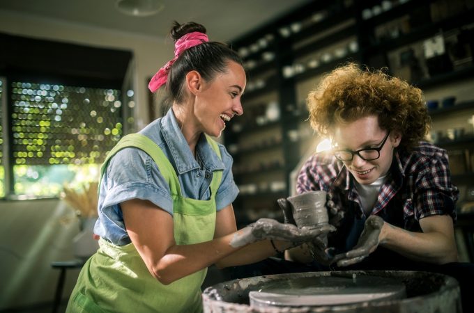 two pottery artist working on the pottery wheel in workshop