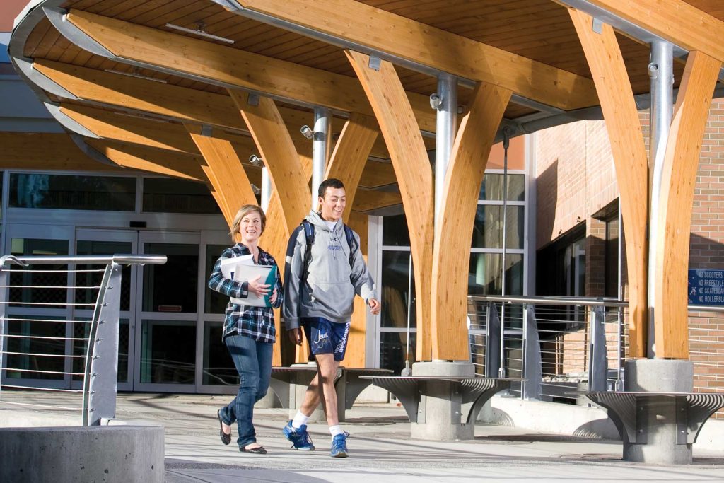 Two students outside the front entrance of Kootenay Center at College of the Rockies