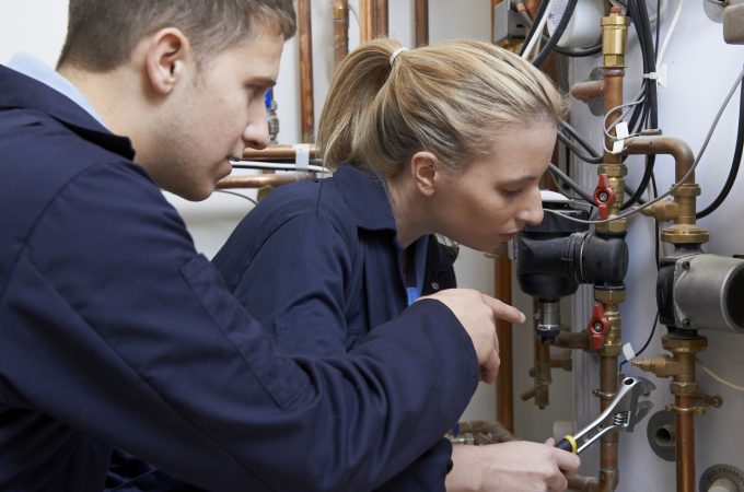 Female Trainee Gasfitter Working On Central Heating Boiler