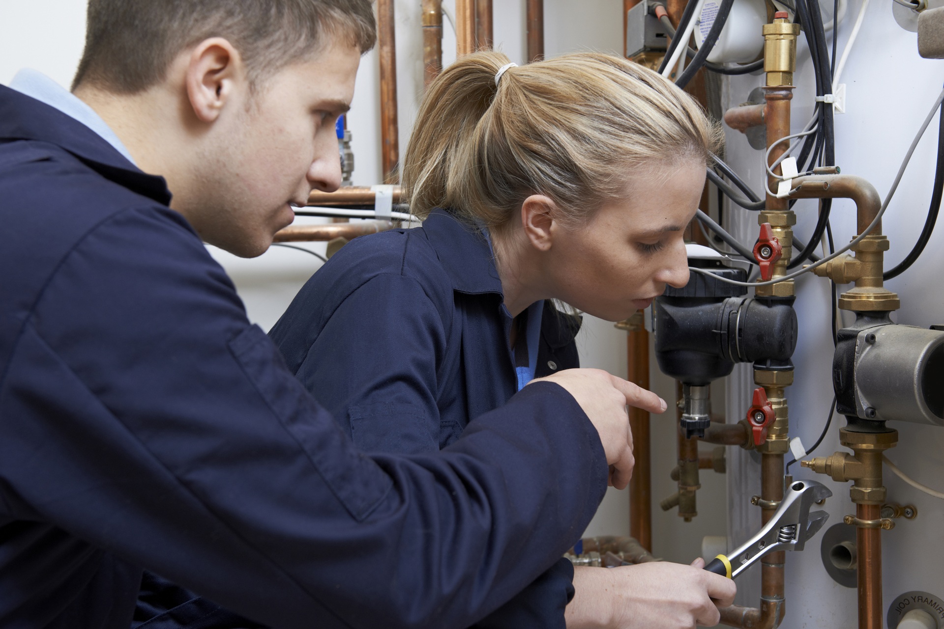 Female Trainee Gasfitter Working On Central Heating Boiler