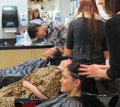 Image of hairstylist students washing hair of clients.