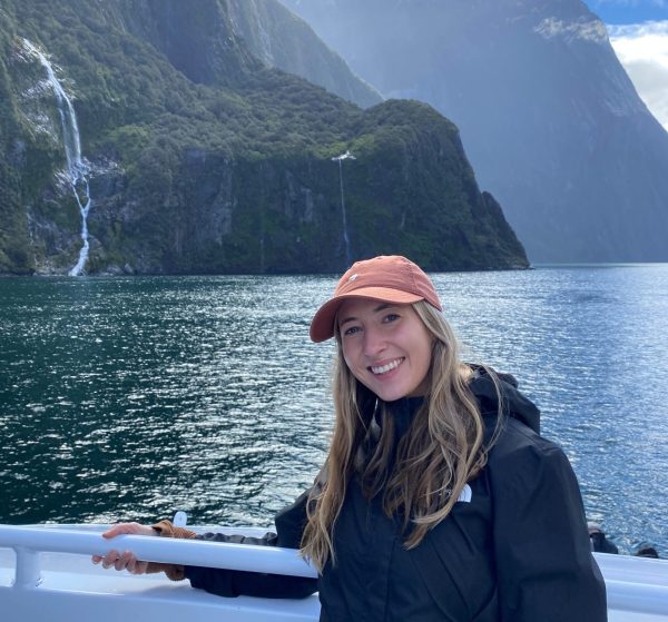 Image shows woman in a boat at Milford Sound fjords in New Zealand.