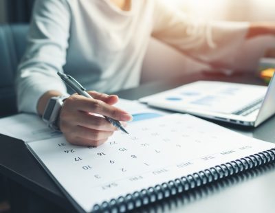 Business woman sitting working and thinking to planner event with calendar and laptop, computer on table at office or home or internet cafe.