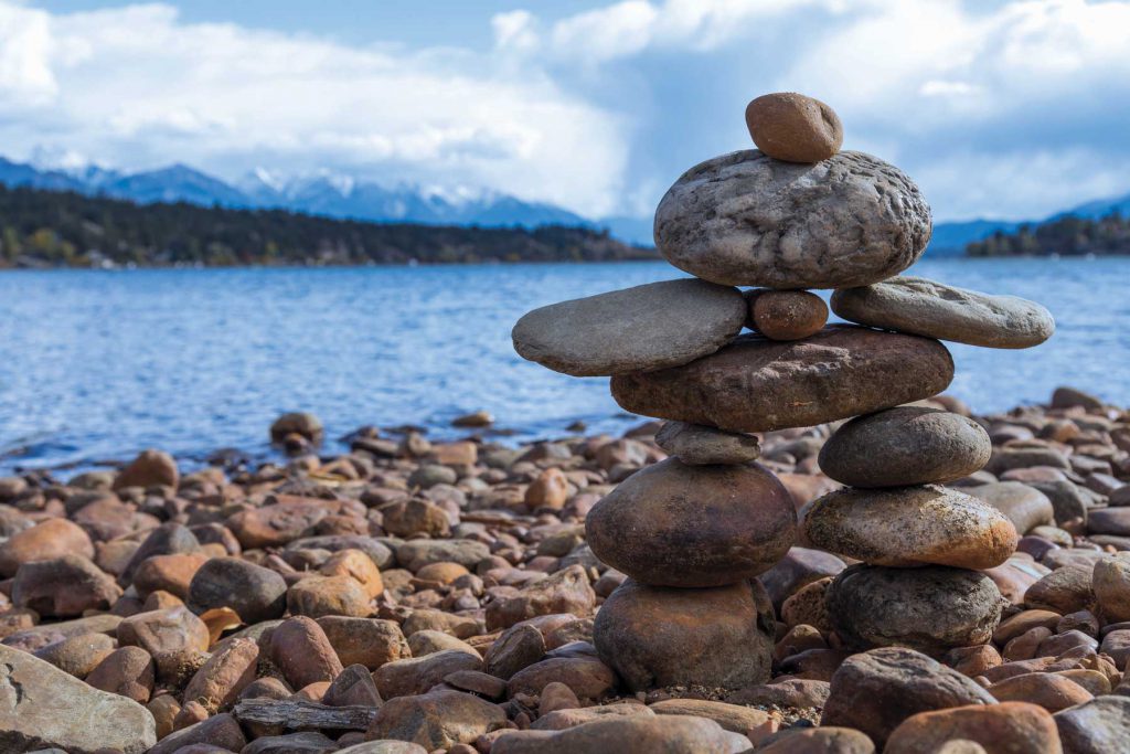 An image of an inukshuk with Lake Windermere in the background.