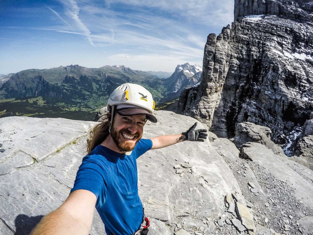 Image of man with helmet rock climbing.