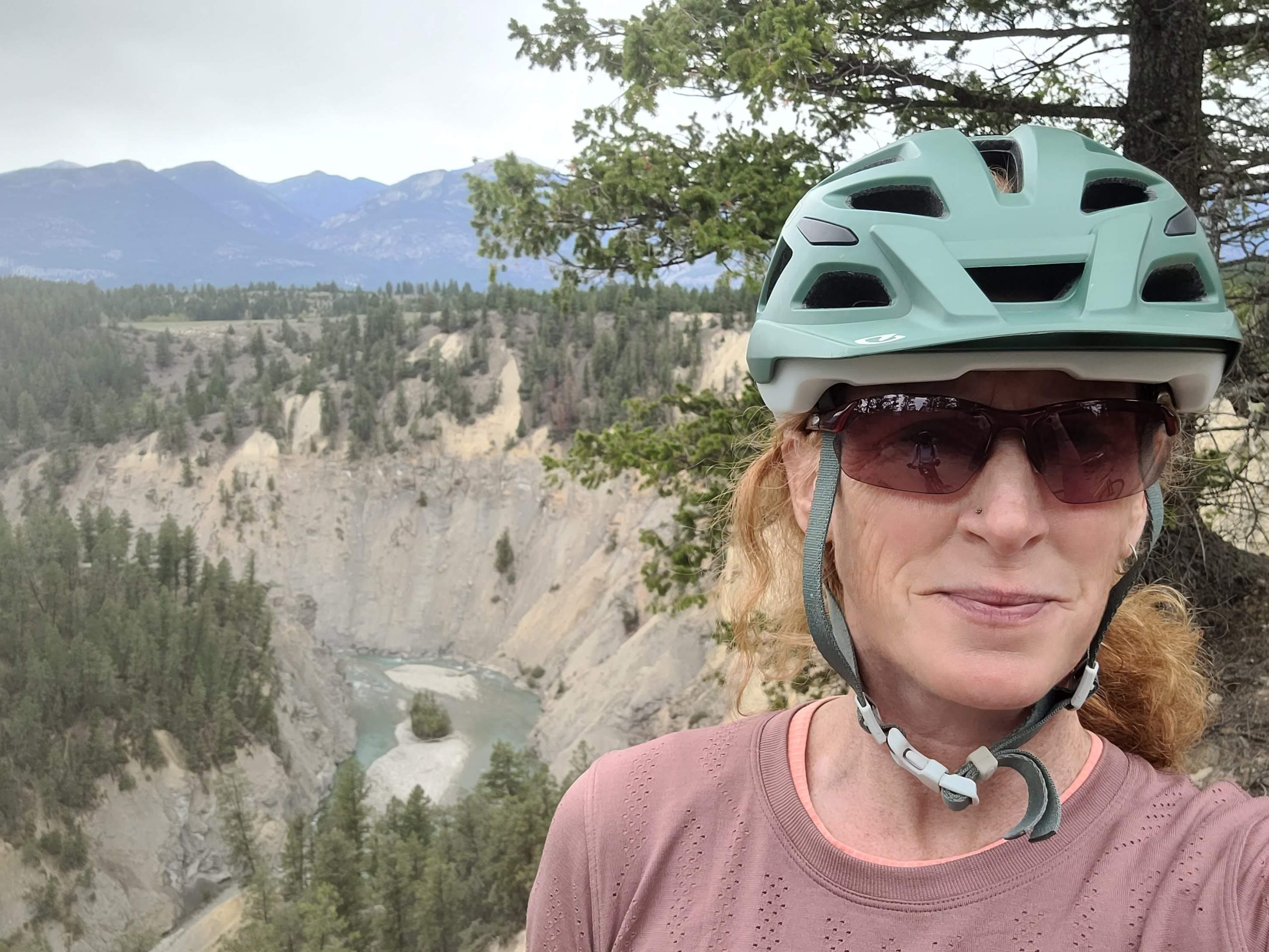 Jani Vogell headshot, wearing helmet while mountain biking in the Kootenay region of BC.