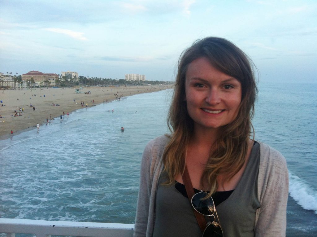 Image of woman standing in front of a body of water.