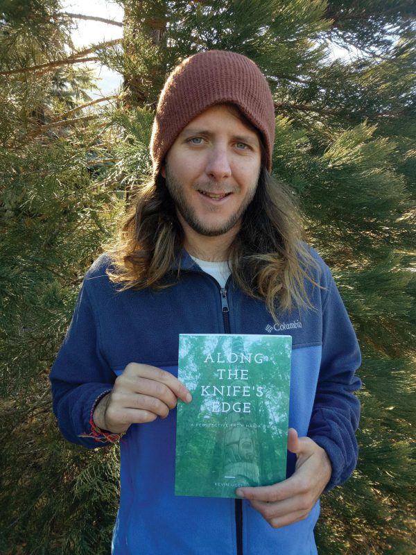 Image shows Kevin Ucci holding his travel book
