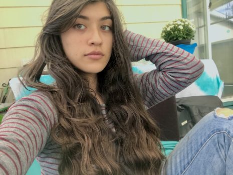 Image shows woman with long dark hair looking toward camera