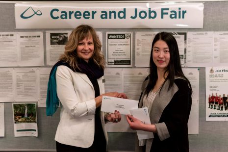College of the Rockies Director, Student Affairs presents an envelope to draw winner Nhung (Mia) Nguyen