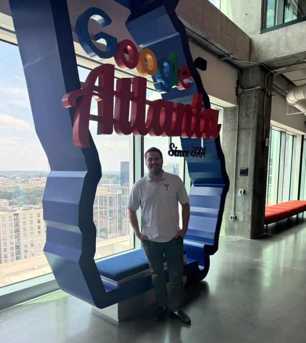 Image shows man standing in front of a Google Atlanta sign.