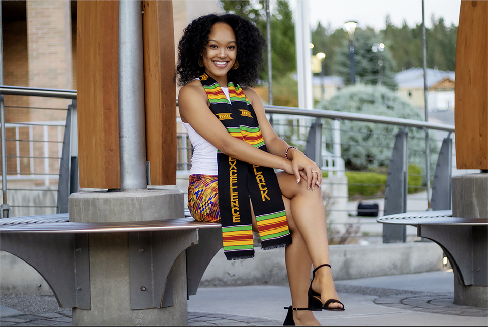 Image shows woman wearing a colourful scarf sitting outside College of the Rockies.