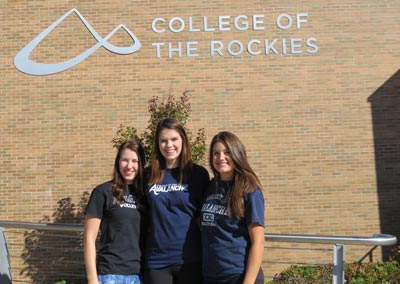 Image shows three female volleyball players outside College of the Rockies