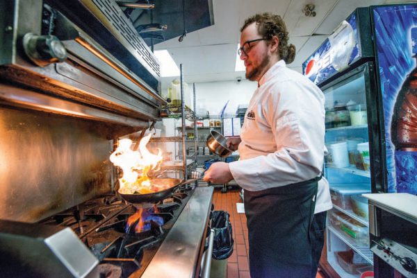A Professional Cook alumni at a flambe station.