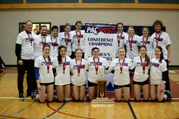 Image of College of the Rockies women's volleyball team with PACWEST conference champs banner and trophy.
