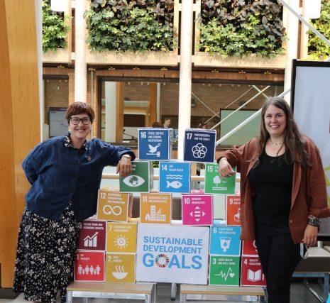 Image shows two College of the Rockies faculty members leaning on blocks describing the UN Sustainable Development Goals