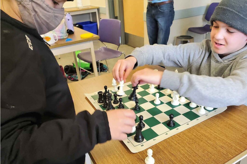 An image of two young male students playing chess.