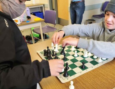 An image of two young male students playing chess.