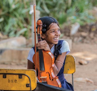 Image of young girl holding violin and smiling