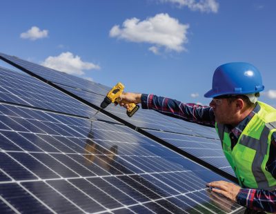 Solar, energy and electricity with a man engineer on a farm to install a panel for alternative power generation. Sustainability, agriculture and carbon footprint with a male technician outdoor.