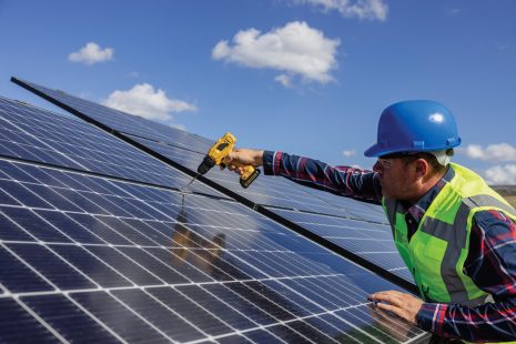 Solar, energy and electricity with a man engineer on a farm to install a panel for alternative power generation. Sustainability, agriculture and carbon footprint with a male technician outdoor.