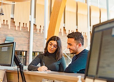 Image shows two people at College of the Rockies Registration desk