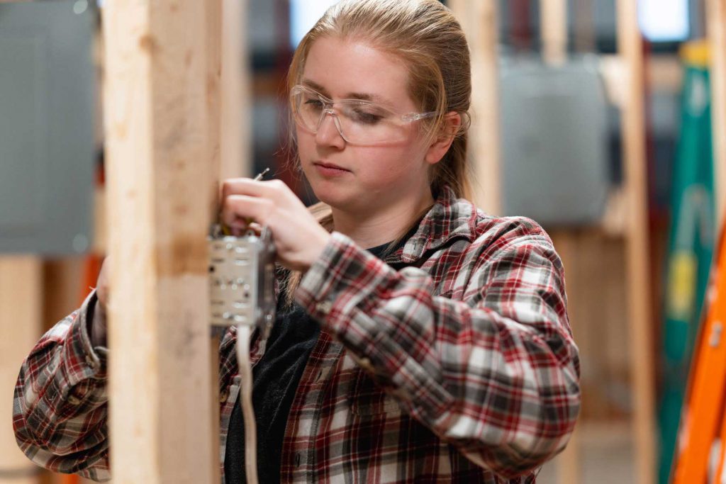 An image of a female electrician working on a jobsite.