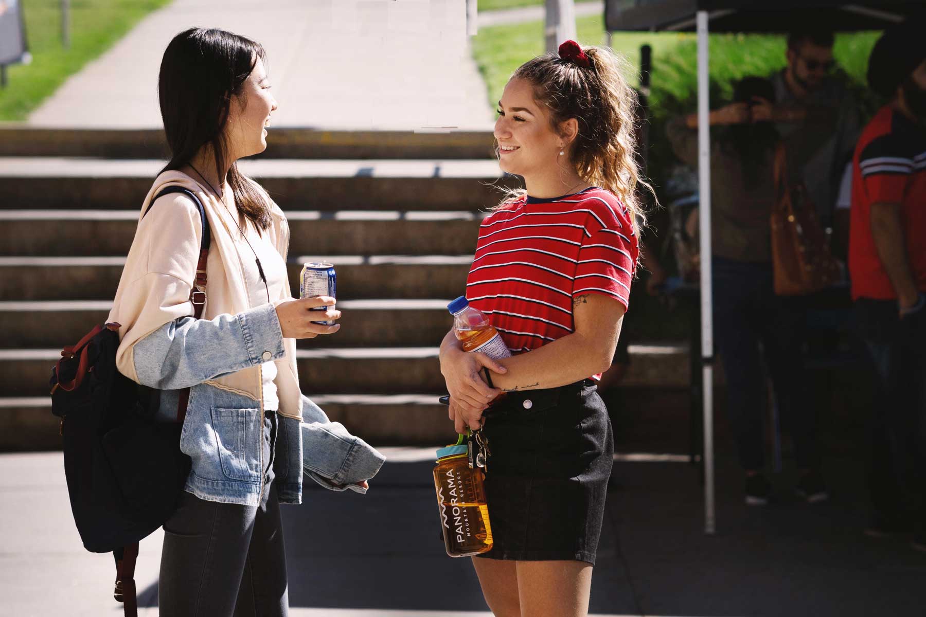 An image of two femals students chatting outdoors.
