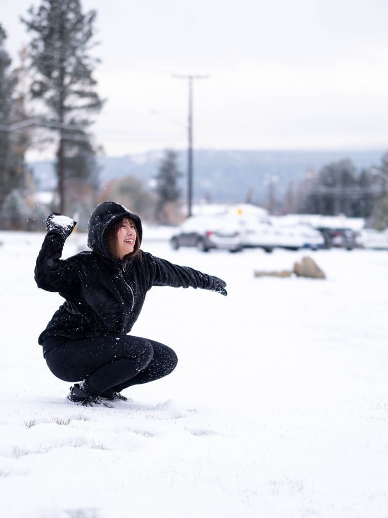 Student tossing a snowball on a wintry day.