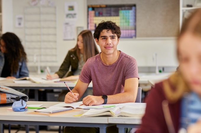 Male student sits at desk.