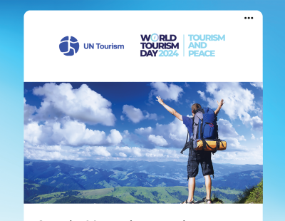 Image shows man standing on the top of a mountain with arms stretched in a 'v' above his head. A World Tourism Day Banner sits atop the image.