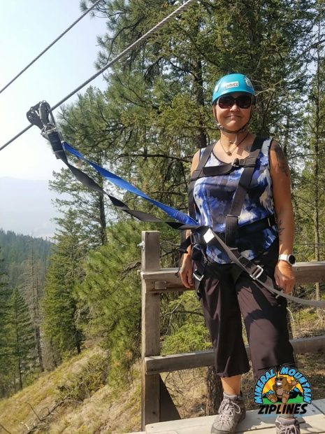 Image shows woman outdoors preparing to zipline.