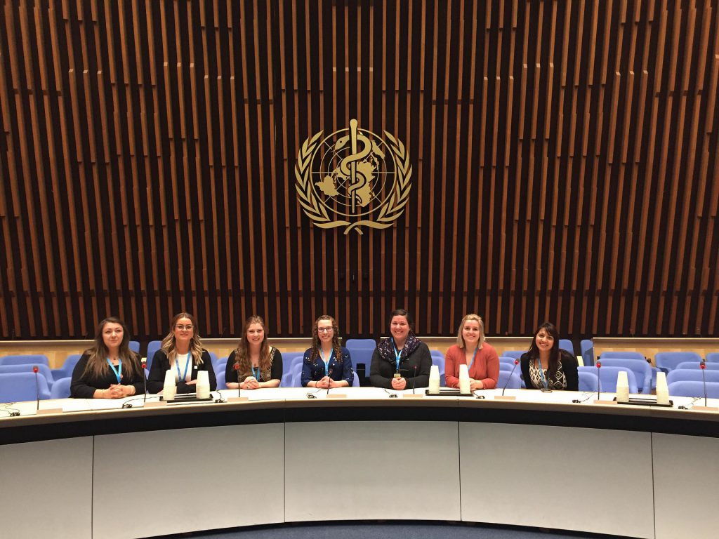 An image of several nursing students sitting at a table at the United Nations.