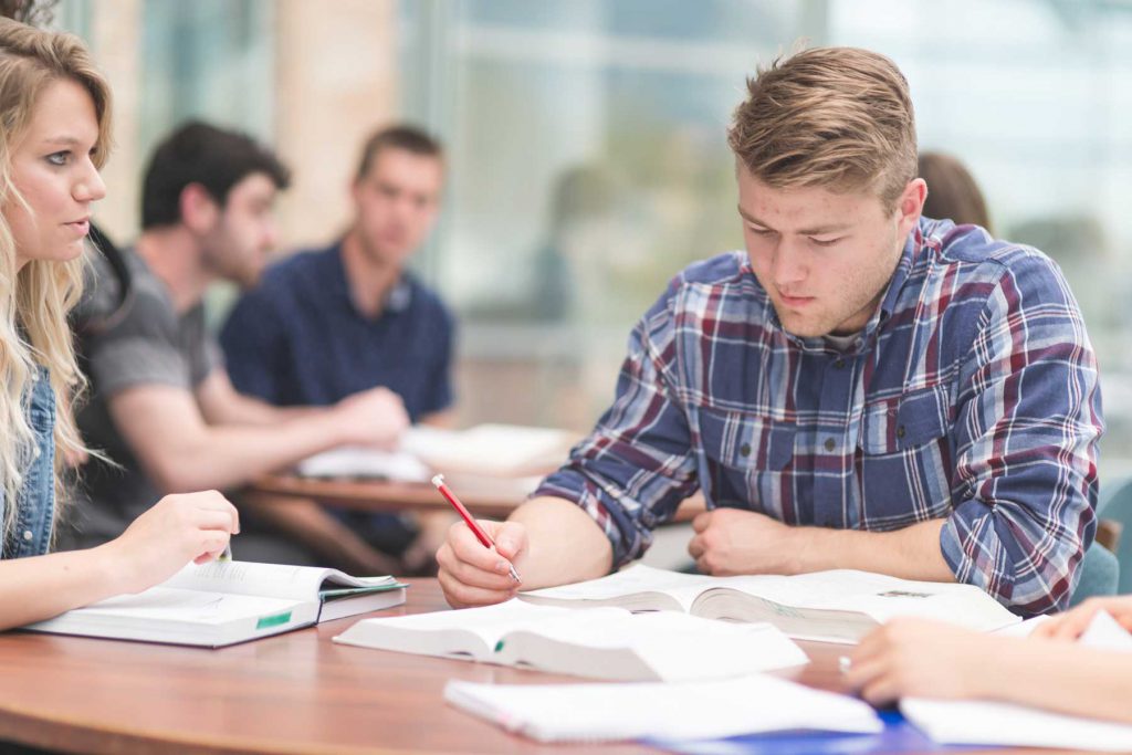 An image of four adult learners sitting in a classroom.