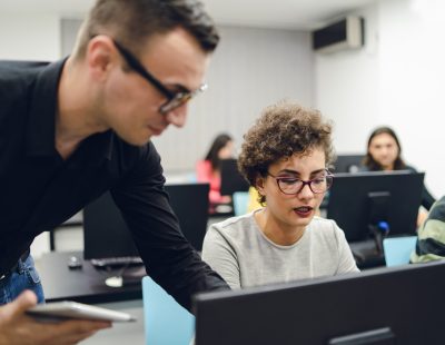 Young people in programming school. Young teacher, explaining the material.